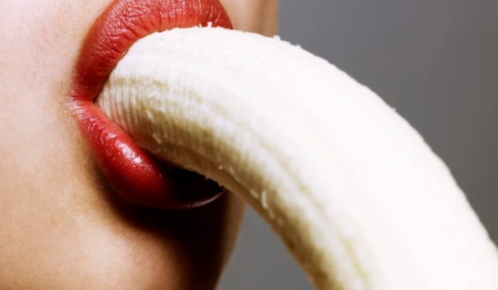 Iš arti moteris, valganti bananą