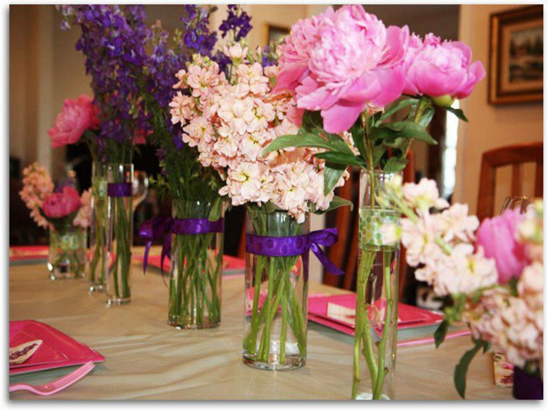 אגרטלים רבים עם פרחים על השולחן