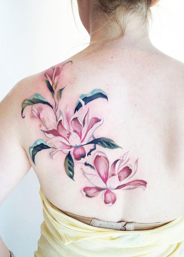 Sırttaki pembe manolya çiçeği dövmesi - kadınlar için kadınsı bir dövme fikri