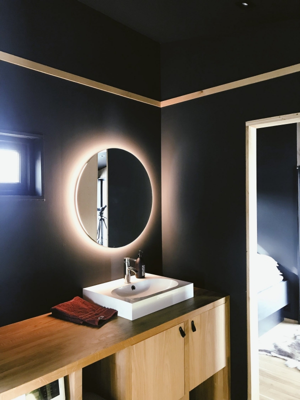 Gjeldende baderomsinnredningstrender og ideer mørke vegger med speilbelysning