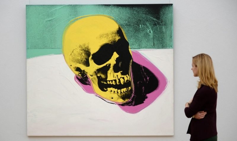 epa04498086 Žena se dívá na dílo „Lebka“ (1976) od amerického umělce Andyho Warhola během náhledu na výstavu „Andy Warhol - smrt a katastrofa“ v muzeu „Kunstsammlung Chemnitz“ v Chemnitz, Německo, 21. listopadu 2014. 61 Kusy Warholovy skupiny děl s názvem „Smrt a katastrofa“ jsou v muzeu vystaveny do 22. února 2015. EPA / HENDRIK SCHMIDT