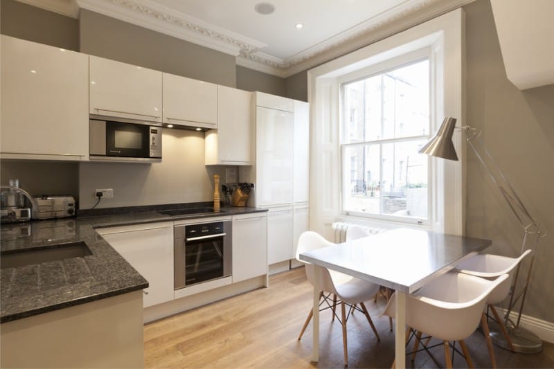 Balta ir smėlio spalvos virtuvės interjere modernaus stiliaus