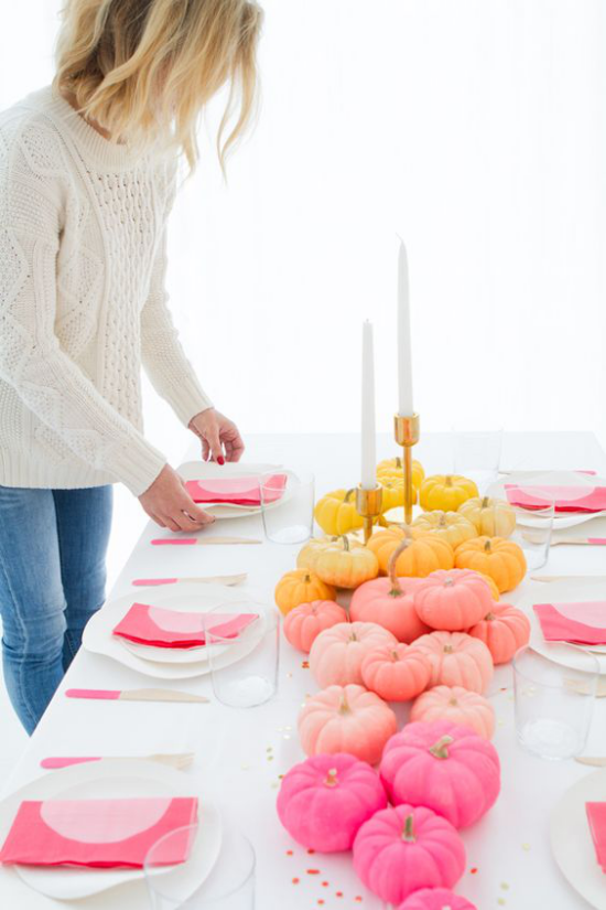 Podzimní výzdoba stolu s dýní, slavnostní prostírání růžově žlutých dýní uprostřed