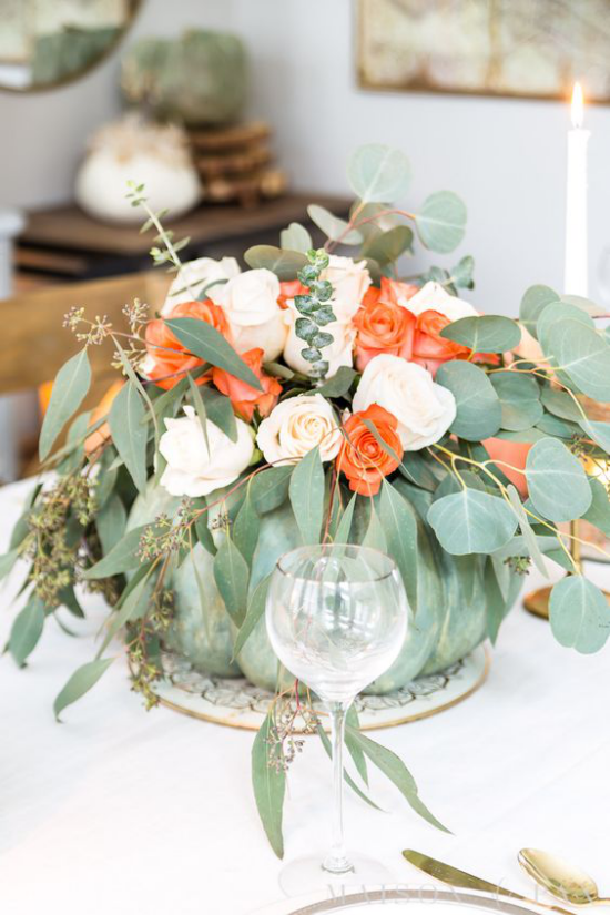 Podzimní dekorace stolu s dýňovými růžemi, eukalyptovými listy, zeleným dýňovým poutačem