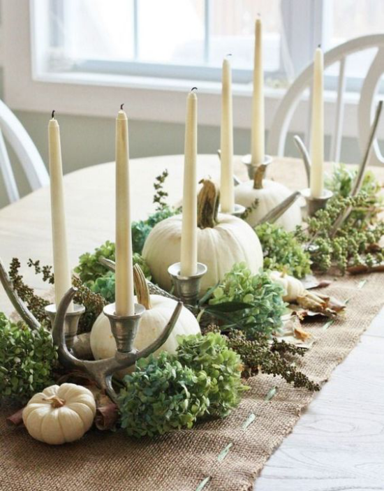 Podzimní dekorace stolu s dýní, bílými dýněmi, bílými svíčkami, nějakou zelenou