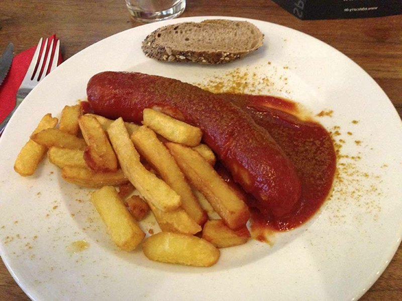 Server pølsen med karrisaus og pommes frites