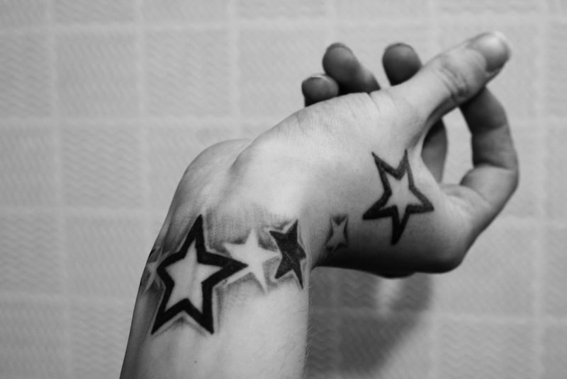 stjerne tatovering ideer svart underarm hånd
