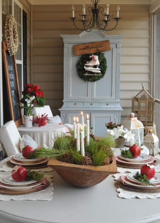 Dřevěná mísa umělé trávy šišky bílé svíčky dekorace stolu červená jablka vánoční hvězda v pozadí