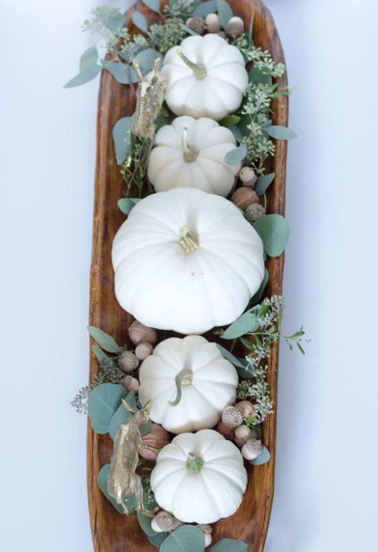 Dřevěná mísa podzimní dekorace stolu bílé dýně v dřevěné misce uspořádané žaludy