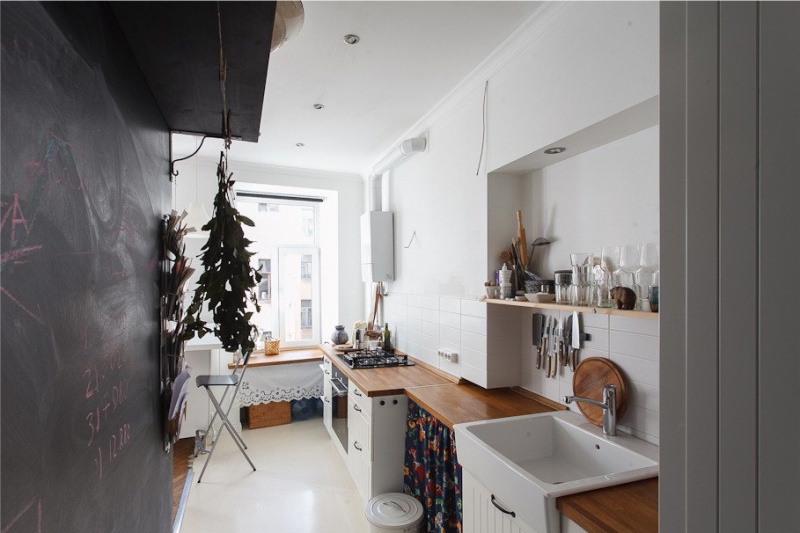 Dujinis vandens šildytuvas virtuvės interjere su baltomis sienomis