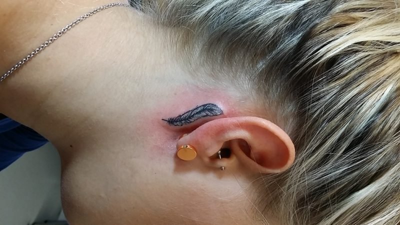 Tetování peří za uchem