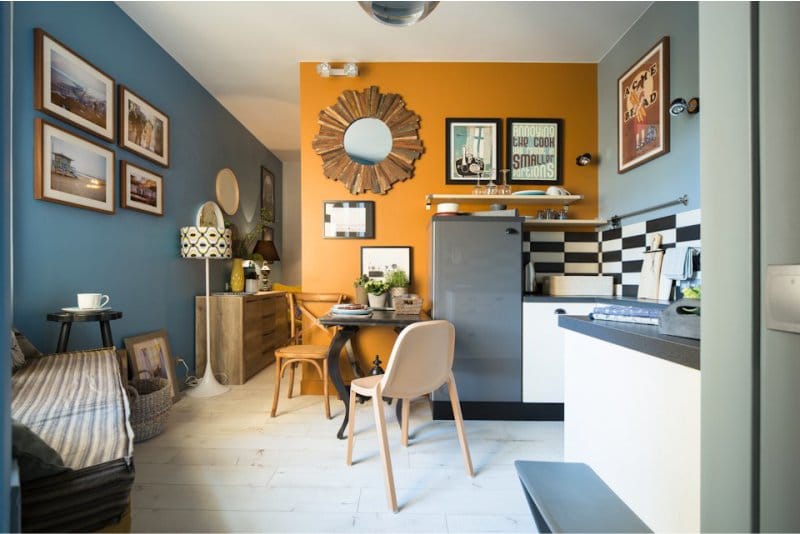オレンジ色のアクセントの壁が付いたカフェスタイルのキッチン