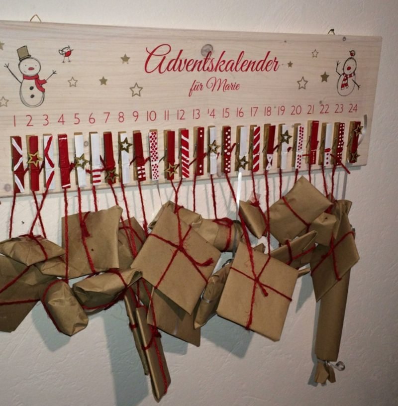 Originální adventní kalendáře dělají dárky na dřevěné desce kolíčky