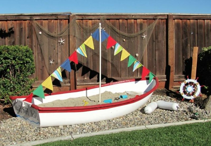 Παιδική χαρά με σκάφος με άμμο και κήπο με άμμο