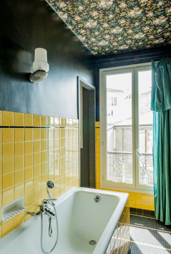 Ταπετσαρία στο ταβάνι σε λουλουδάτο μοτίβο στο μπάνιο λεμόνι κίτρινα πλακάκια μπανιέρα τυρκουάζ κουρτίνα στο παράθυρο